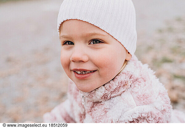 Toothless baby girl blonde caucasian in a hat smiling