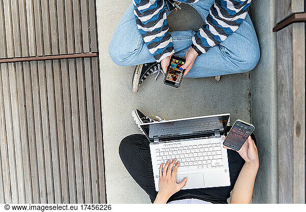 Top down detail view of young people using computer and smart phones