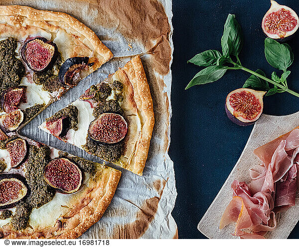 Top down view of ricotta  fig and pesto pizza with prosciutto