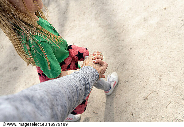 top down view of young blond girl holding hands