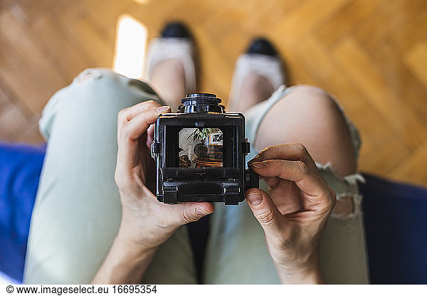 Top view of a girl takes a photo with her medium format camera.