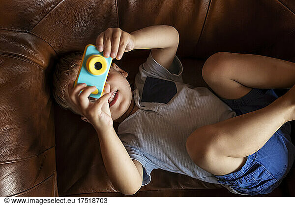 Top view of boy taking photo with toy camera
