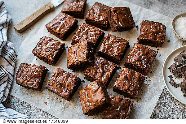 Top view of chocolate brownies cut into squares on paper.