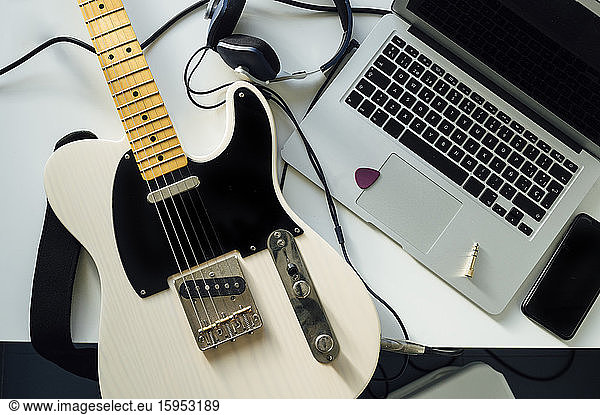 Top view of electric guitar  laptop  smartphone and headphones