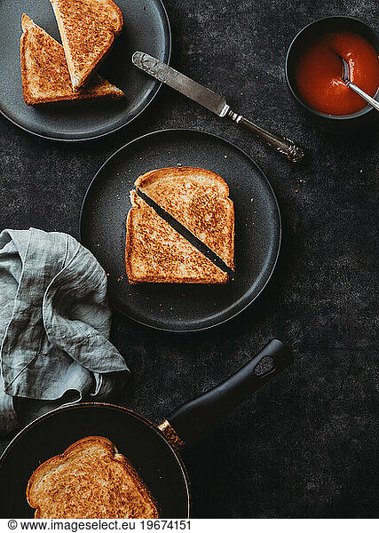 Top view of grilled cheese sandwiches and soup black background.