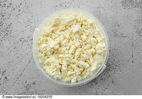 Top view of homemade cottage cheese in plastic bowl