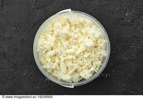 Top view of homemade cottage cheese in plastic bowl