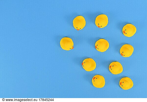 Top view of many yellow rubber ducks on blue background with copy space
