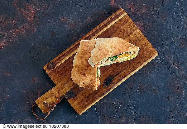 Top view of pita bread stuffed with chicken  tomato and omelette