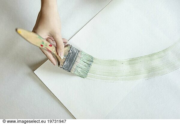 Top view woman painting with big brush