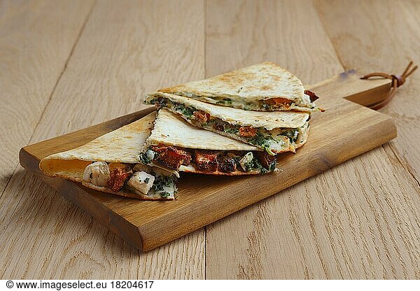 Tortillas stuffed with meat  vegetables and cheese on serving plate
