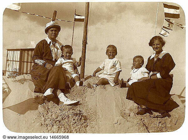 tourism  two women with children sitting in sand on the beach  Germany  circa 1914