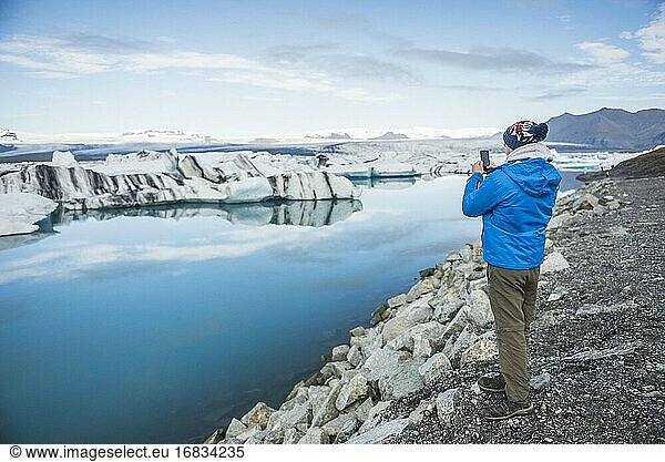 Tourist an der Jokulsarlon Gletscherlagune  einem mit Eisbergen gefüllten Gletschersee im Südosten Islands