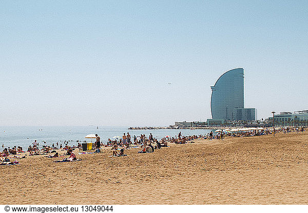 Tourist entspannt sich am Strand des Hotels W Barcelona bei klarem Himmel
