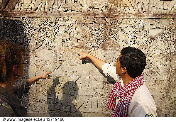 Tourist guide showing elephants and warriors. Relief Sculpture on the East Outer Gallery at Bayon.