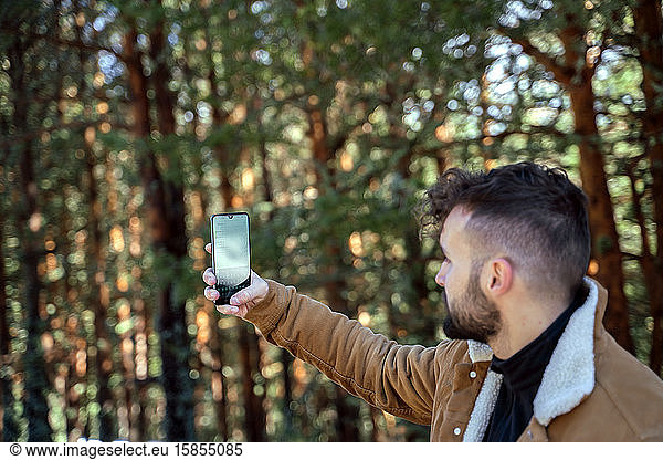 Tourist in den Bergen konsultiert das Smartphone