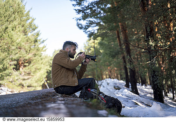 Tourist in den Bergen ruht sich mit seiner Kamera aus