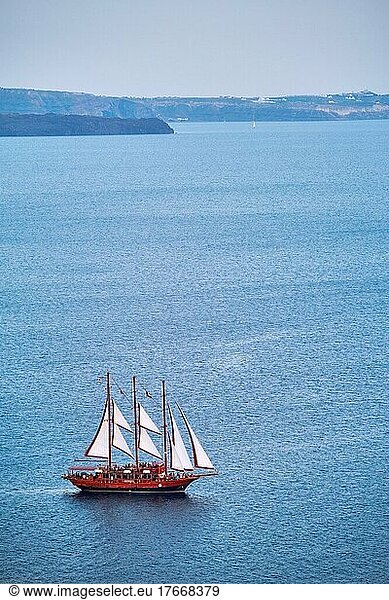Tourist schooner vessel ship boat in Aegean sea near Santorini island with tourists going to sunset viewpoint. Santorini  Greece  Europe
