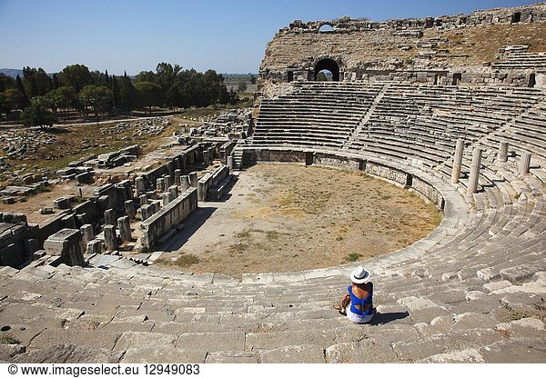 Tourist sitting at the stairs of the theatre in the ancient ruins of Miletus  Milet  Aydin Province  Turkey  Europe