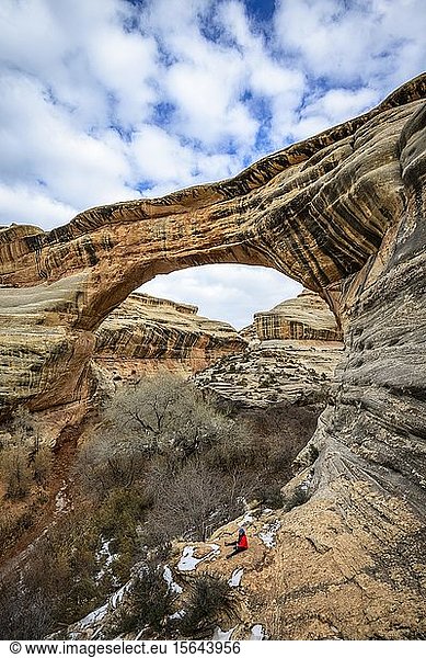 Tourist sitzt unter Felsbogen  Sipapu-Brücke  Natural Bridges National Monument  Utah  USA  Nordamerika