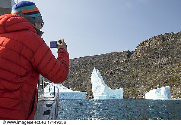 Tourist takes photograph of icebergs  Arctic Ocean.
