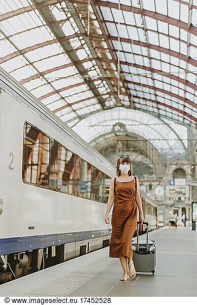 Tourist woman with mask walking inside Antwerp train station