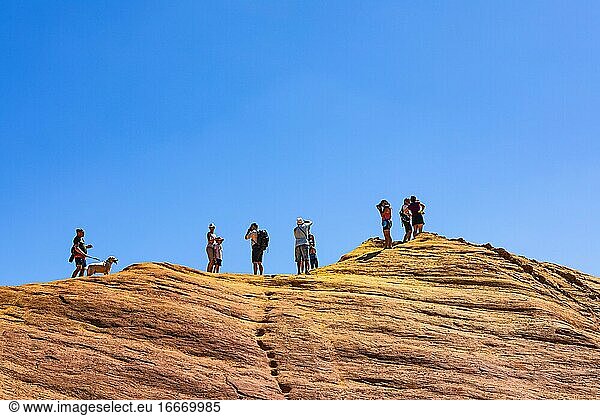 Touristen auf der Spitze eines Ockerfelsen  darüber blauer Himmel  Colorado Provencal Naturpark  Rustrel  Luberon  Provence