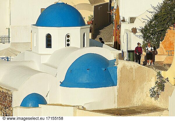Touristen in der Nähe der blauen Kuppelkirchen im Dorf Oia  Insel Santorin  Kykladen  Griechische Inseln  Griechenland  Europa.