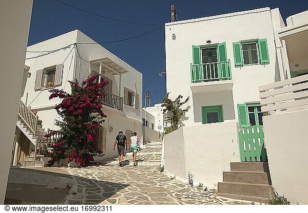 Touristenpaar vor den traditionellen weiß getünchten Häusern mit bunten Türen und Fenstern im Dorf Naoussa  Insel Paros  Kykladen  Griechische Inseln  Griechenland  Europa.