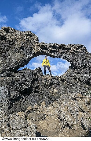 Touristin steht in einem Felsbogen  Lawafeld Dimmuborgir  Myvatn  Norðurland eystra  Island  Europa