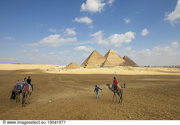 Tourists exploring the Great Pyramids of Giza on camels