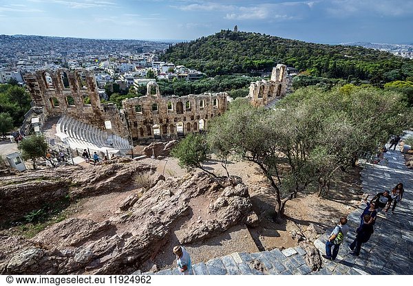 Tourists in ancient Acropolis of Athens city  Greece. View with Odeon of Herodes Atticus.