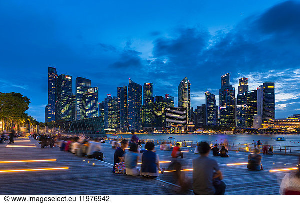 Tourists looking at city skyline from waterfront at dusk  Singapore  South East Asia