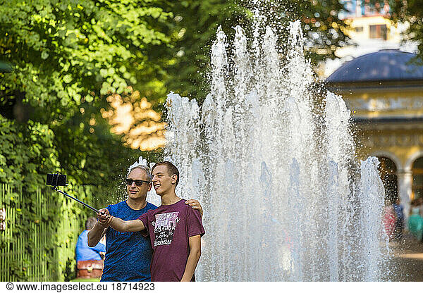 Tourists Taking Picture Together Using Selfie Stick In Summer Gardens Park In Saint Petersburg  Russia