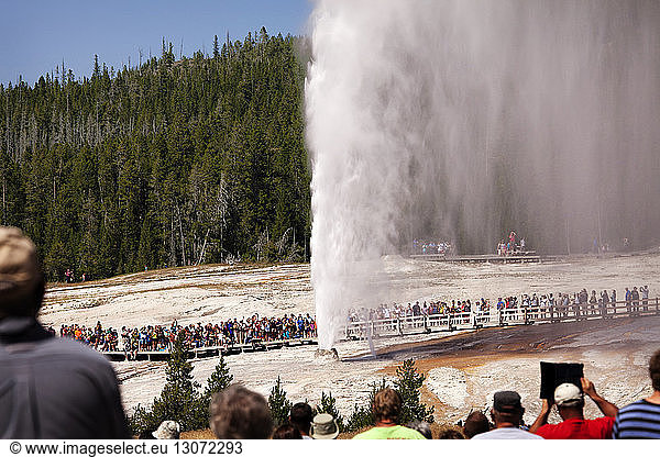 Tourists visiting Old Faithful Geyser at Yellowstone National Park