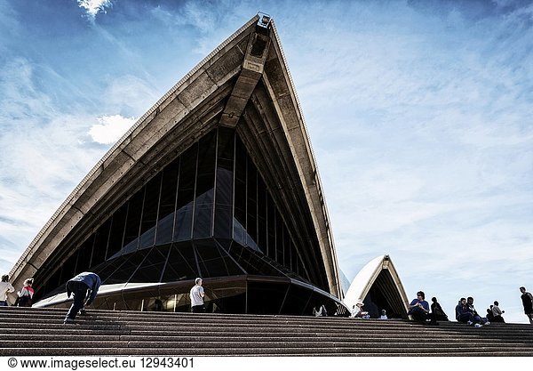 Tourists visiting sydney opera house landmark detail in australia on sunny day.