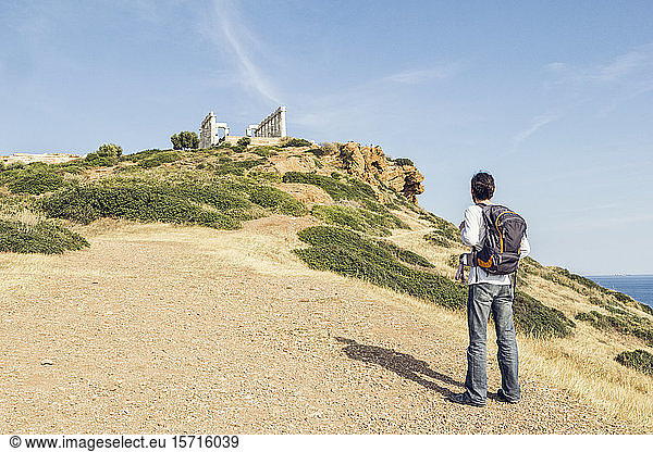 Tourost betrachtet die antike Ruine des Poseidon-Tempels  Kap Sounion  Attika  Griechenland