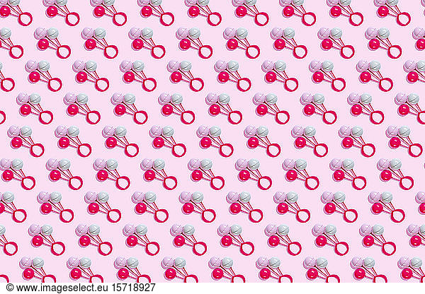 Toy rattle pattern on pink background