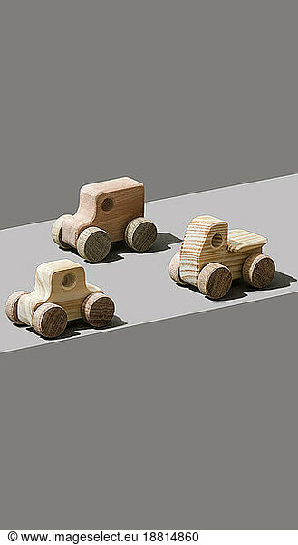 Toy wooden cars on gray background