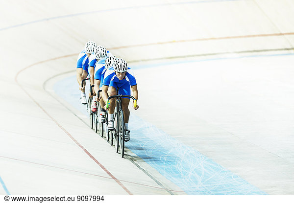 Track cycling team riding in velodrome