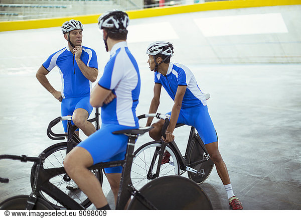 Track cycling team talking in velodrome