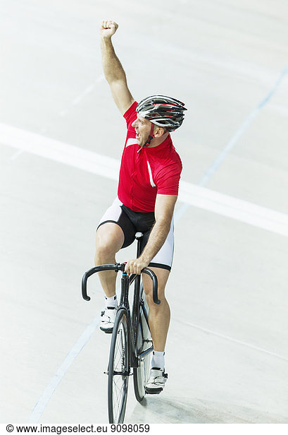 Track cyclist celebrating in velodrome