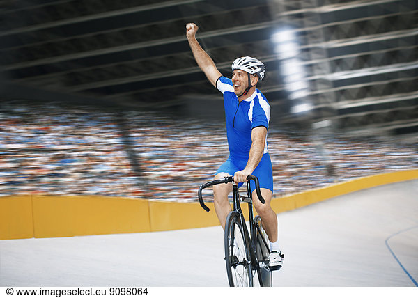 Track cyclist celebrating in velodrome