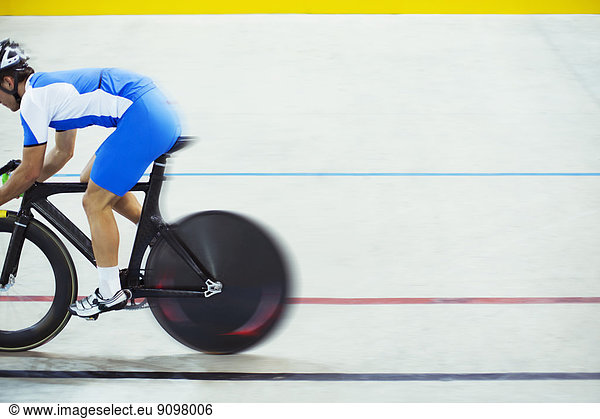 Track cyclist riding in velodrome