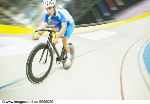 Track cyclist riding in velodrome