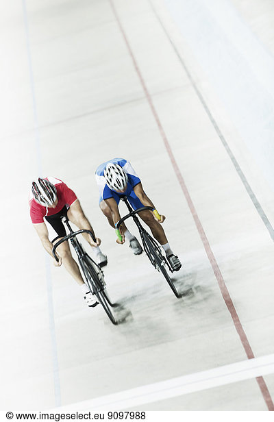 Track cyclists racing in velodrome