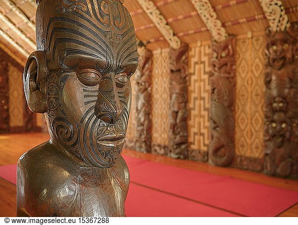 Traditional carving of a Maori statue in the assembly hall Te Whare ...