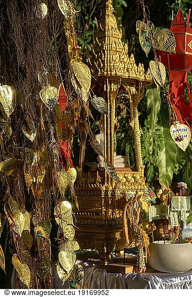 Traditioneller thailändischer Buddha Altar als Busabok mit Geld und Räucherstäbchenopfern  bunten Lanna Laternen. Bodhibaum mit goldenen Blättern mit Wünschen und Versprechen in vielen Sprachen. Selektiver Fokus  unscharfer Hintergrund. Goldener Berg  Bangkok  Thailand  Asien