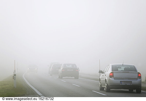 Traffic on road in mist