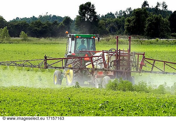 Traktor beim Sprühen von Dünger und Pestiziden auf einem Sojabohnenfeld in der Nähe von Rochester Minnesota MN.